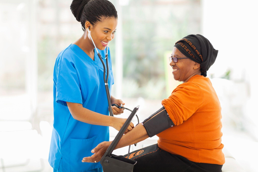 African nurse checking senior patient's blood pressure