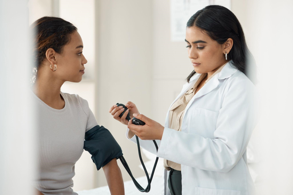 medical worker checking hypertension of a woman at a checkup in a medicare clinic.