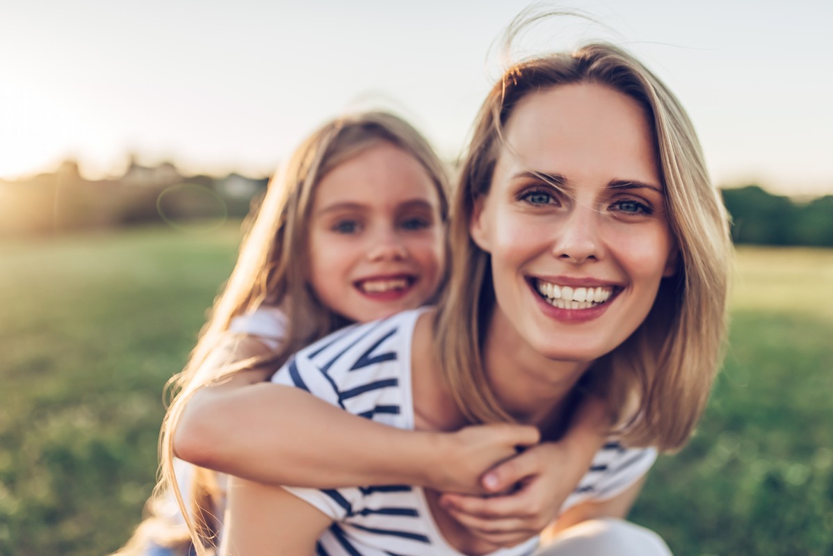 mom with daughter in park during the sunset