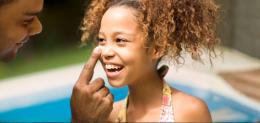 dad applying sunburn to girl's nose