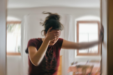 Blured photo of a woman suffering from vertigo or dizziness or other health problem of brain