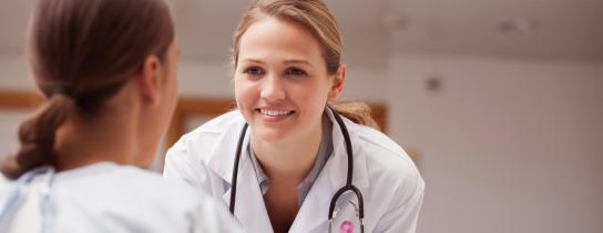 smiling-doctor-looking-at-a-patient-on-a-wheelchair