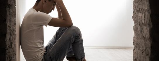 young-man-sitting-on-a-floo-with-hands-on-head