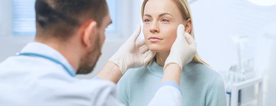 Healthcare provider examining plastic surgery patient's face