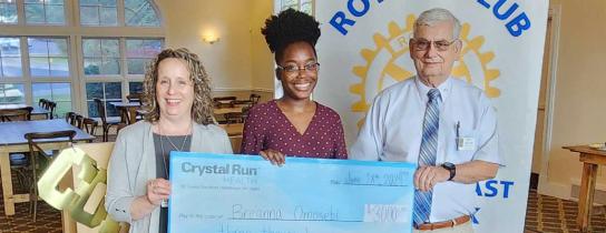 Wallkill East Rotary scholarship winner holding large scholarship check between two presenters