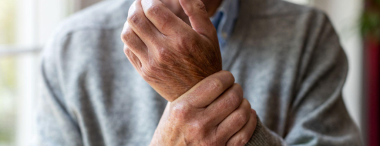 Senior man with arthritis rubbing hands