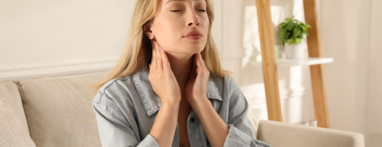 Young woman doing thyroid self examination at home