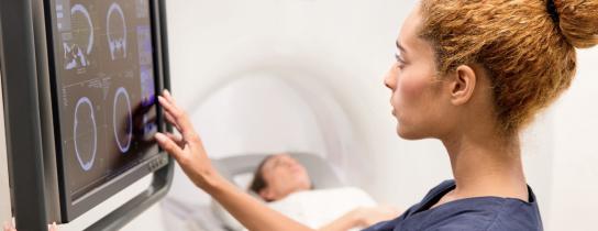 doctor looking at CT scan on screen