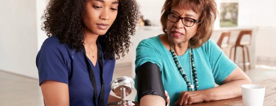 nurse and woman checking blood pressure