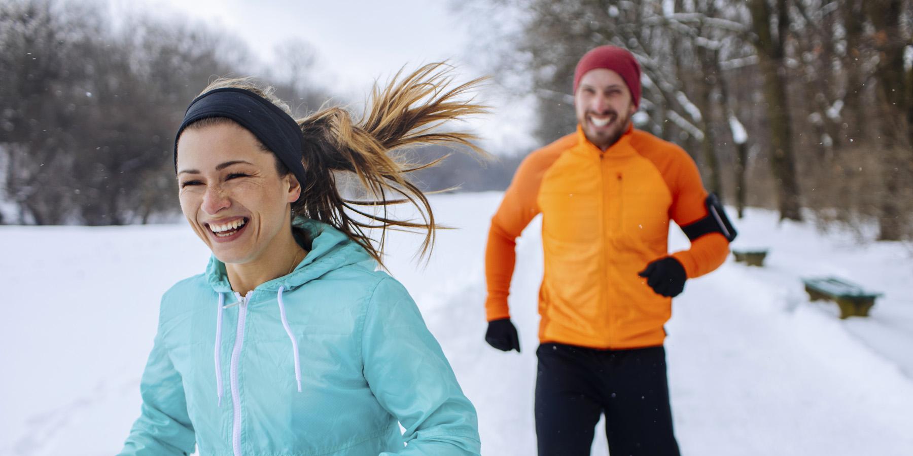 woman and man running in the snow