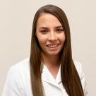 A photo of Alexandriah Sabarese smiling in a lab coat