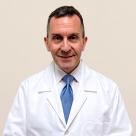 A photo of Joseph Carcione, MD smiling in a lab coat