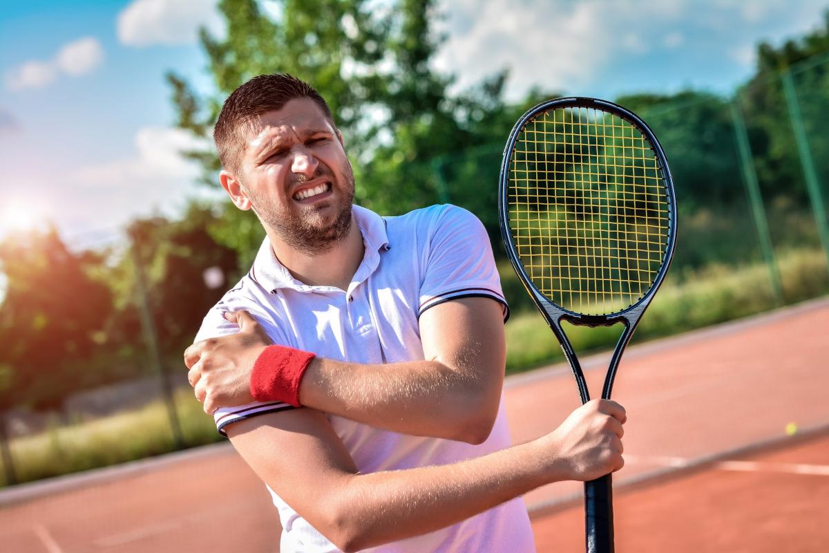 tennis player with a shoulder injury on a clay court